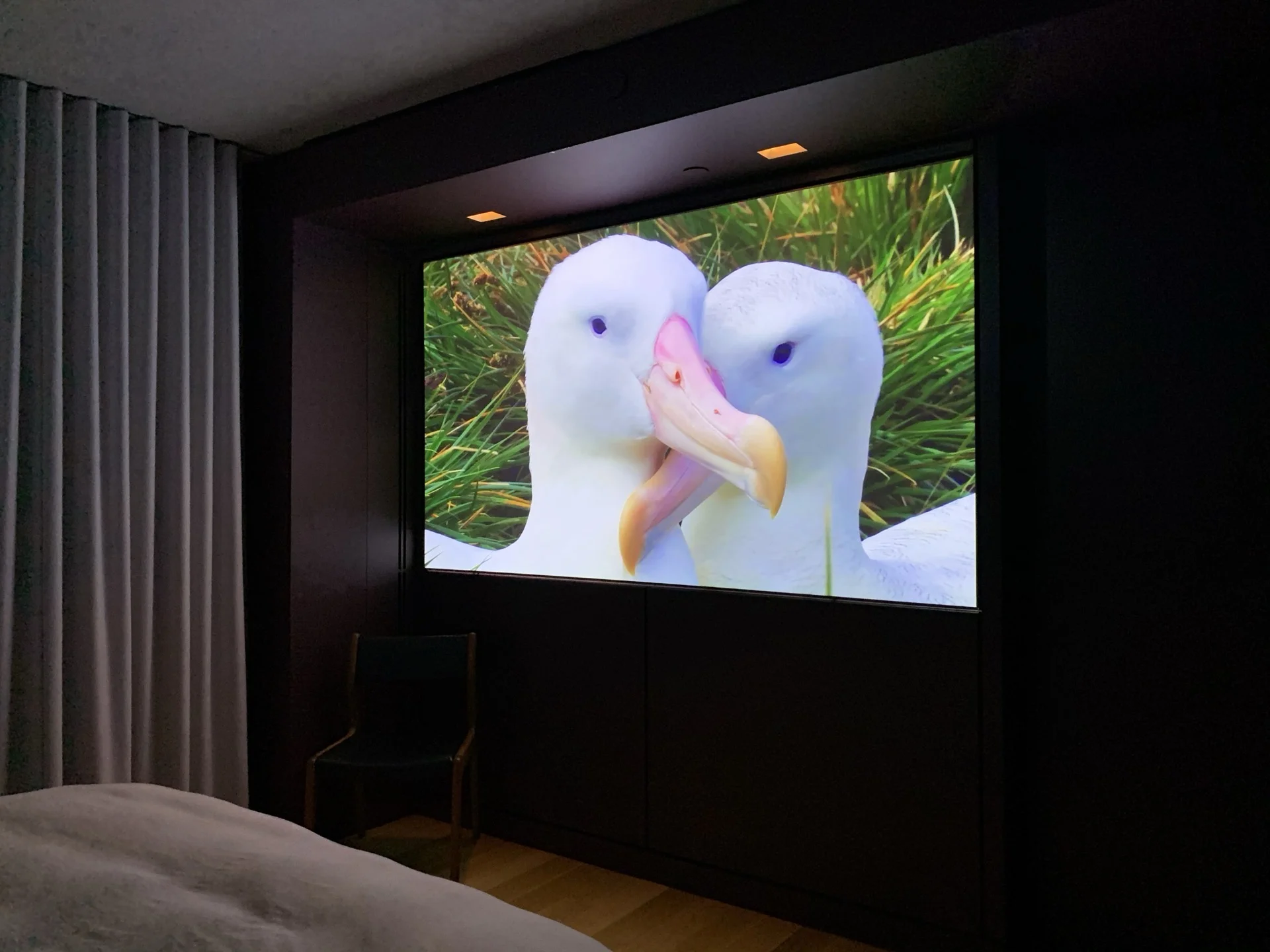 Bedroom with hidden motorized projector system